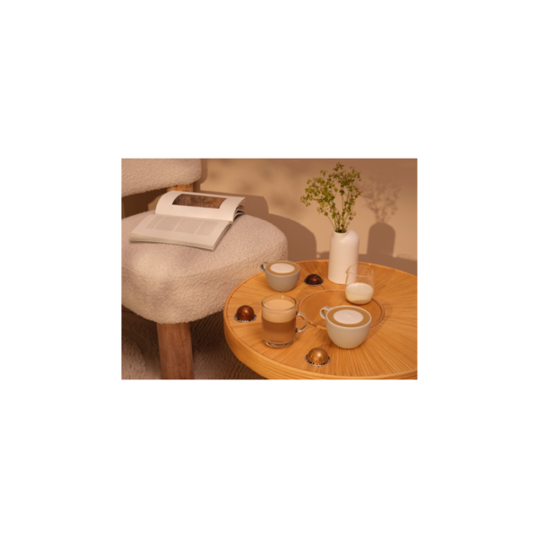 Nespresso Vertuo Bianco Forte capsule next to a mug of creamy latte with foam art, demonstrating its ideal use for milk drink